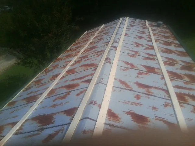 Rusted metal roof panels with new wood purlins before replacement — Storm Damage Roof Repair in Tatum by Roofing Brothers