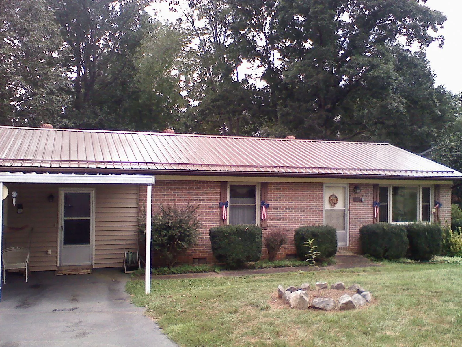 Bronze metal roof and carport on a brick ranch home — Roof Repair work by our crew in Tatum