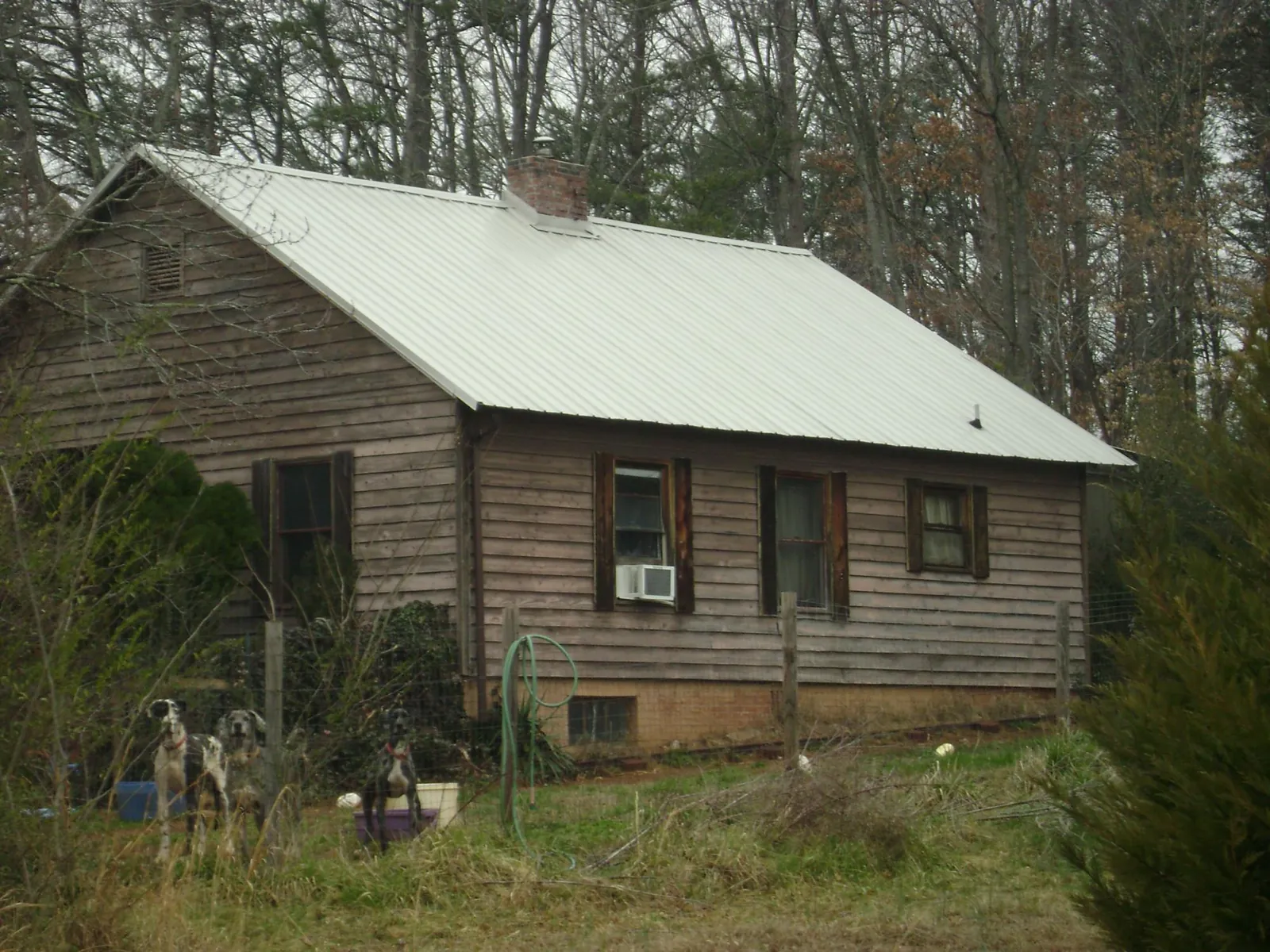 White metal roof on an old wood sided farmhouse, from a Metal Roof Installation job in Tatum